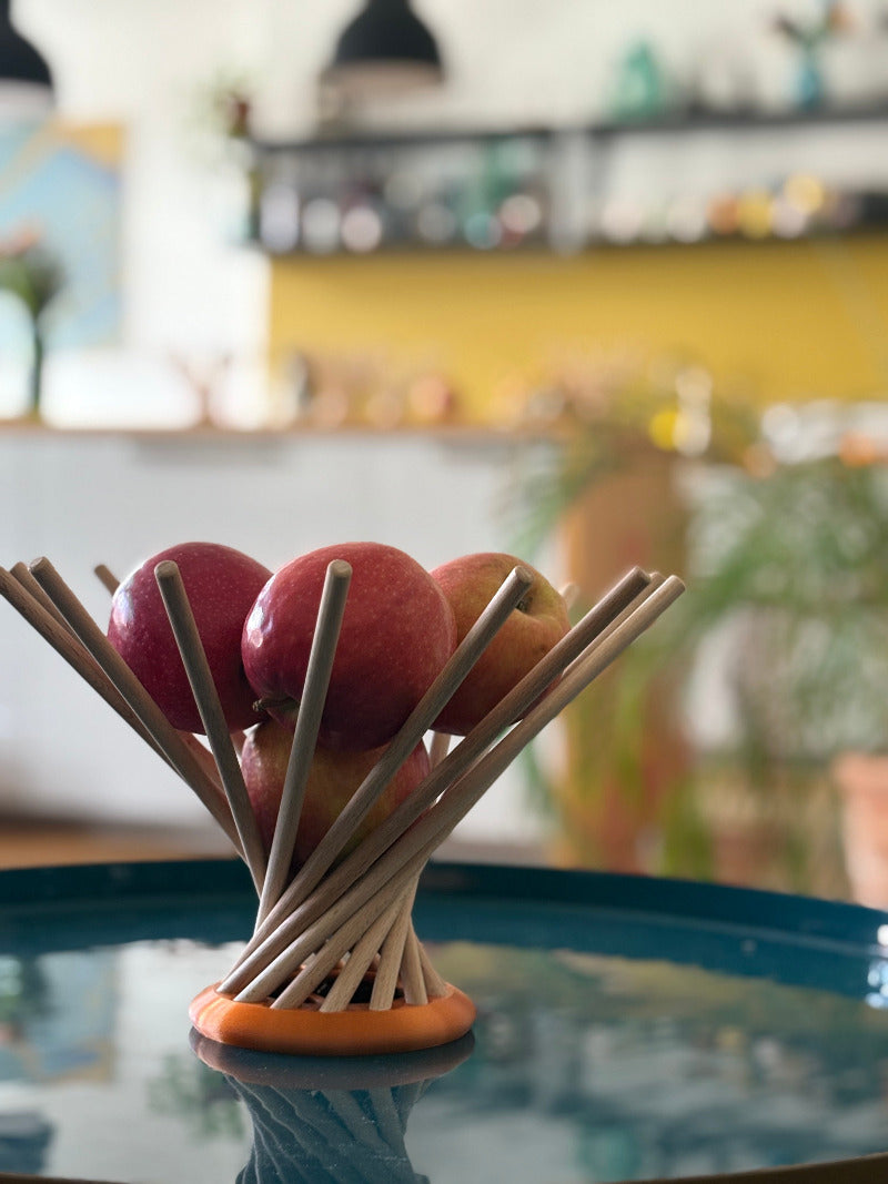 gefüllte Obstschale Dekoschale steckbare Schale auf einem Couchtisch mit einer Küchenzeile im Hitergrund